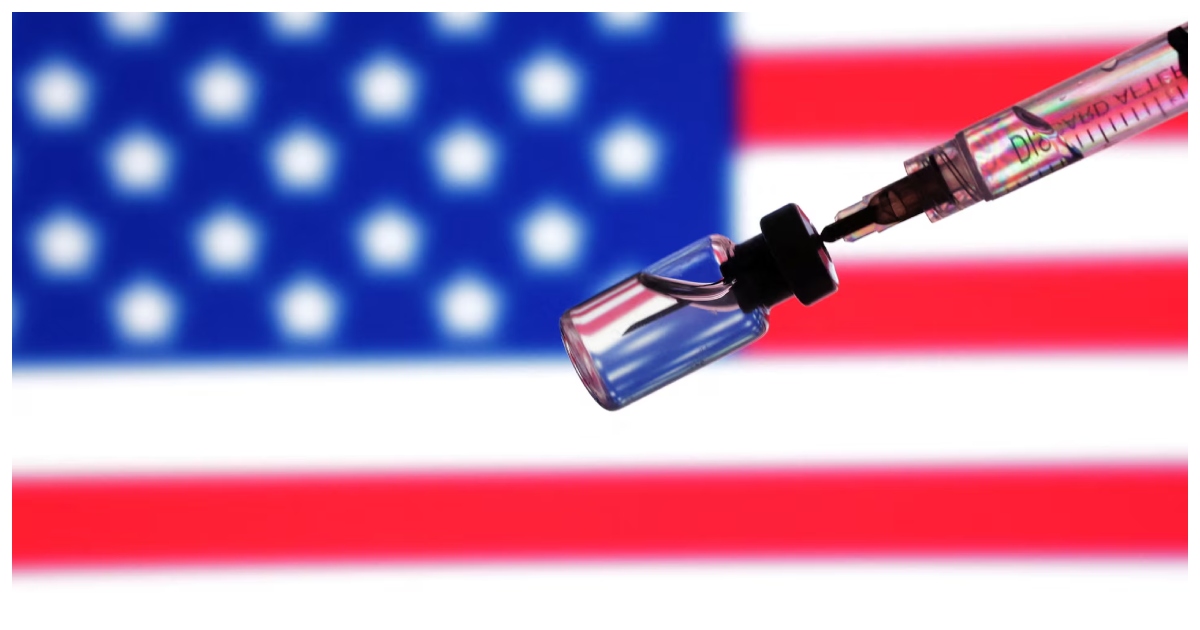 অ্যামেরিকার পতাকার সামনে টিকার শিশি ও সিরিঞ্জ। ছবি: রয়টার্স